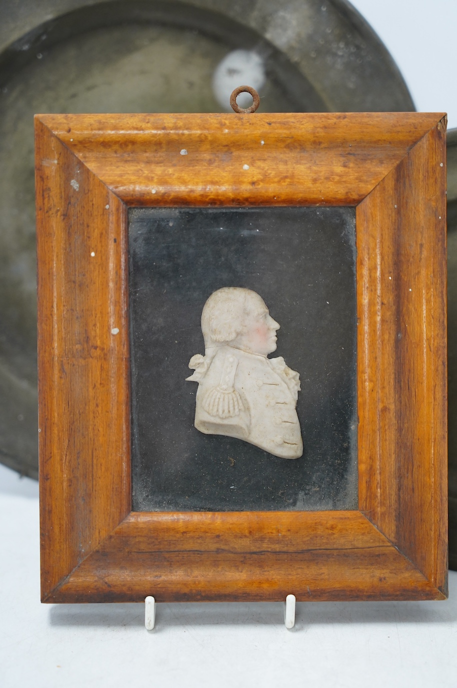 Naval interest; a maple framed coloured waxed profile bust of Admiral Lord Howe, c.1800, together with two pewter plates stamped, London, wax relief including frame 15.5cm wide, 18cm high. Condition - fair, considering a